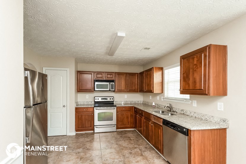 a kitchen with wooden cabinets and stainless steel appliances
