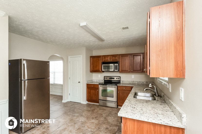 a kitchen with wooden cabinets and stainless steel appliances