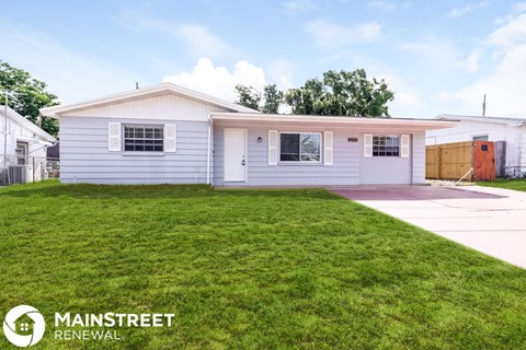 a small white house with a lawn in front of it