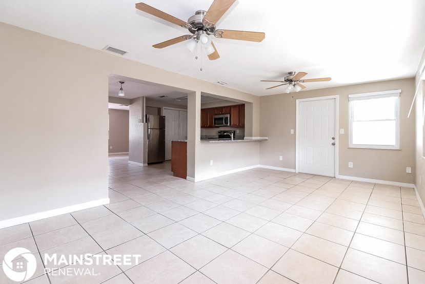an empty kitchen and living room with a ceiling fan