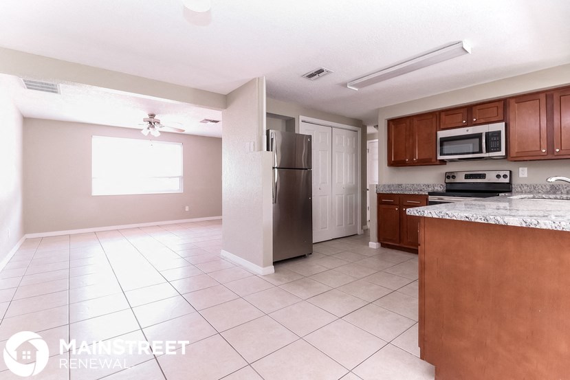 a kitchen with wood cabinets and a stainless steel refrigerator