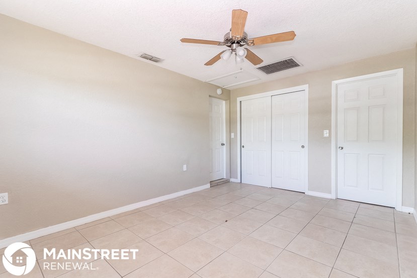 a living room with a ceiling fan and a tiled floor