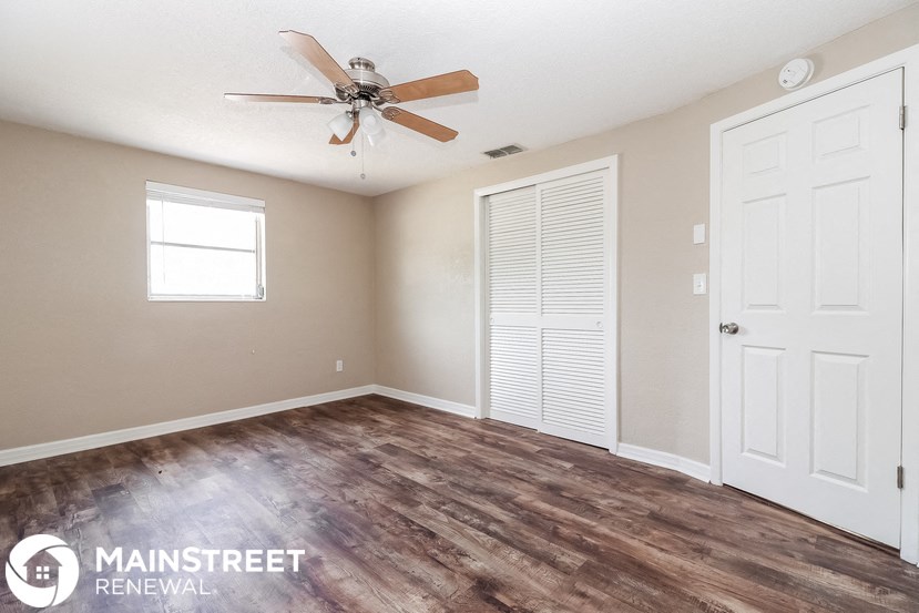 an empty room with a ceiling fan and a closet