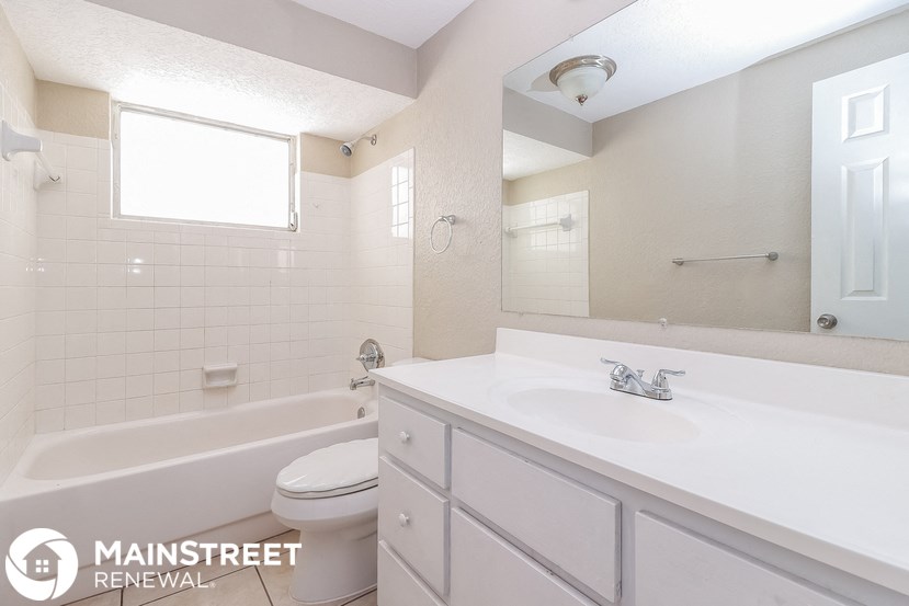a white bathroom with a sink and a toilet and a tub