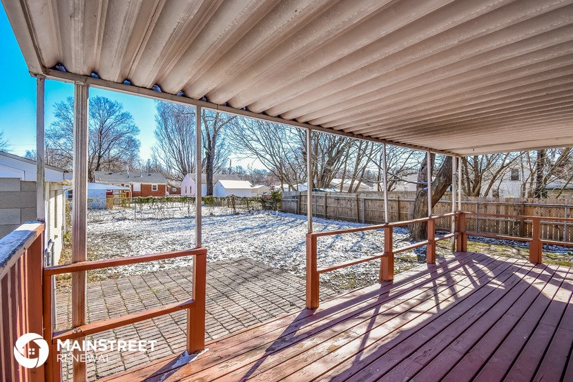 a deck with a fence and a yard with snow
