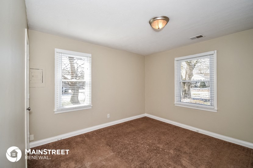 the master bedroom is spacious and has a carpeted floor and two windows