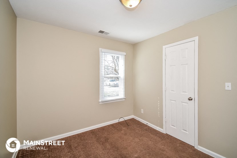 the master bedroom has a carpeted floor and a white door