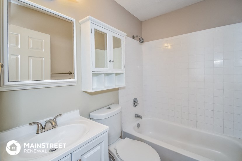 a white bathroom with a tub and a sink and a toilet