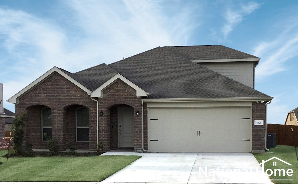 A house with a garage and a driveway in front.