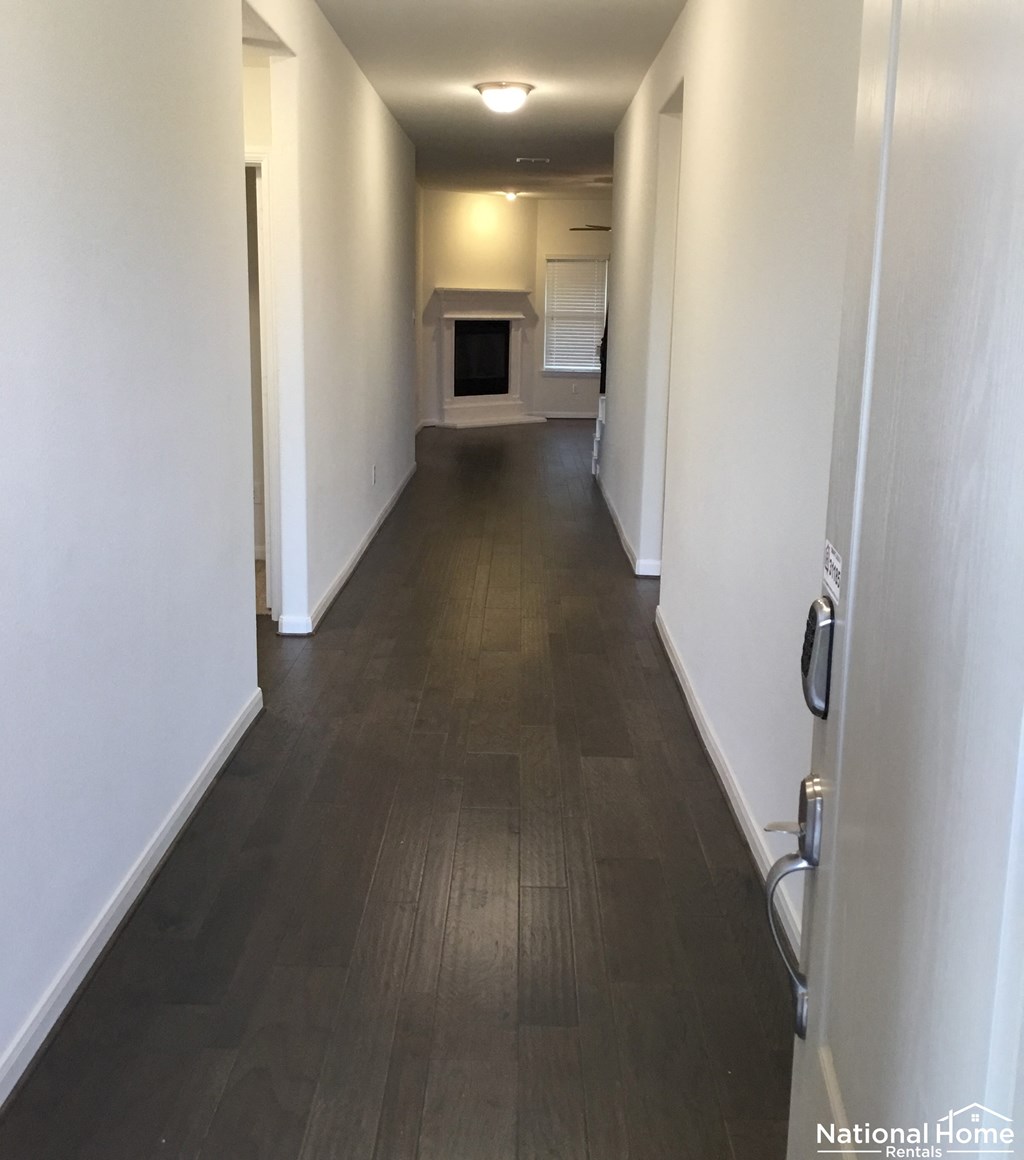 A long hallway with a door on the right.