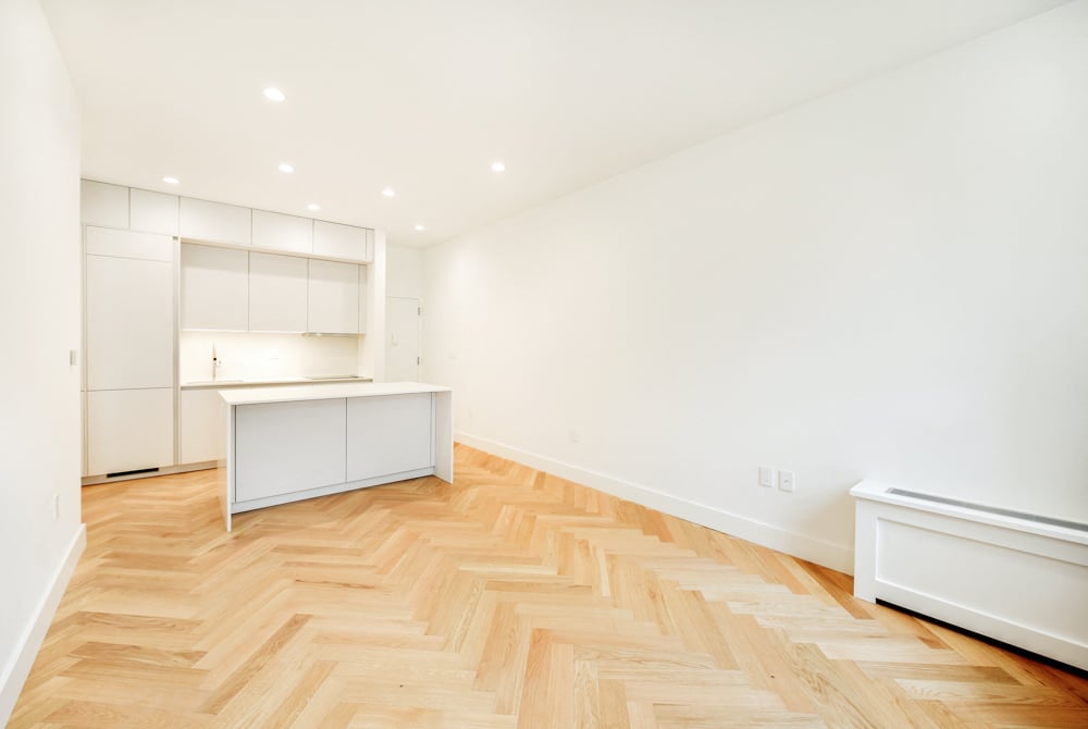 A room with a herringbone patterned wooden floor.