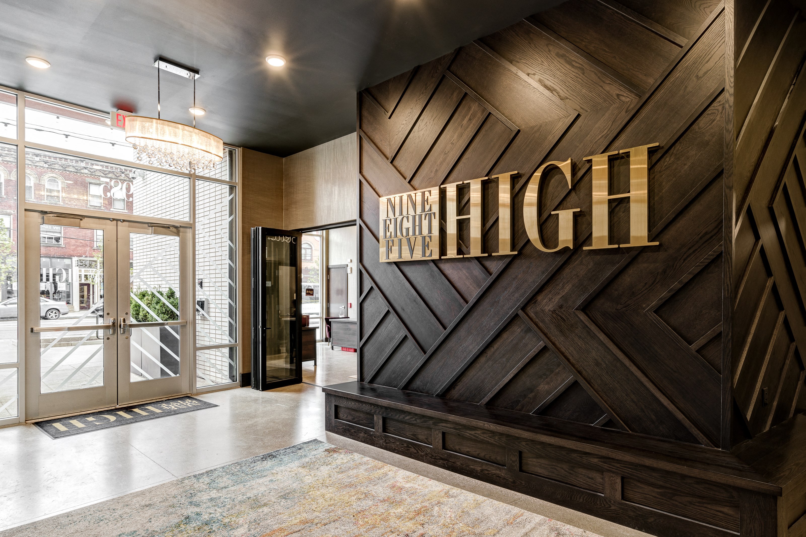 the entrance to the high hotel lobby with a wood wall and gold letters on it