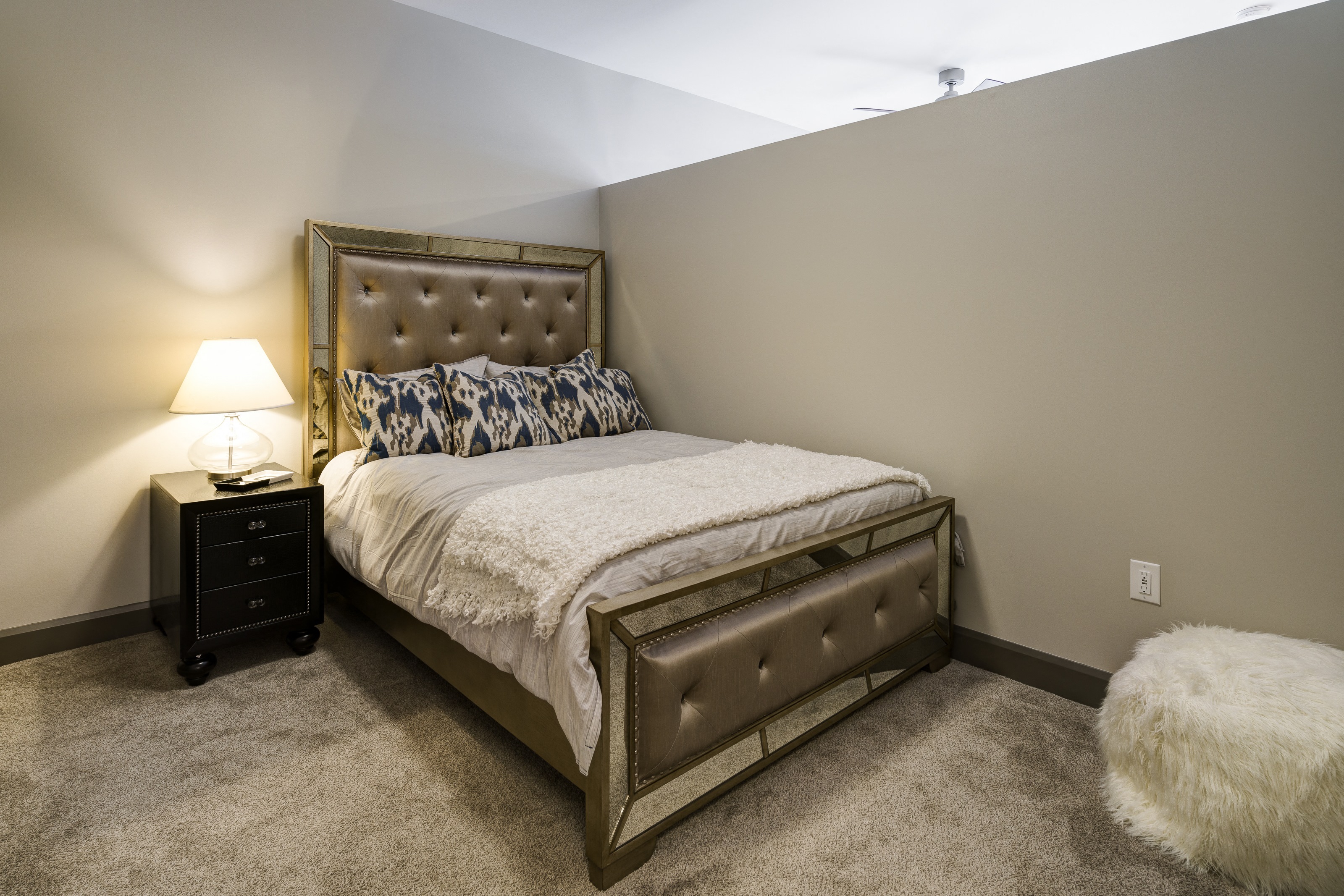 a bedroom with a bed and a white furry rug