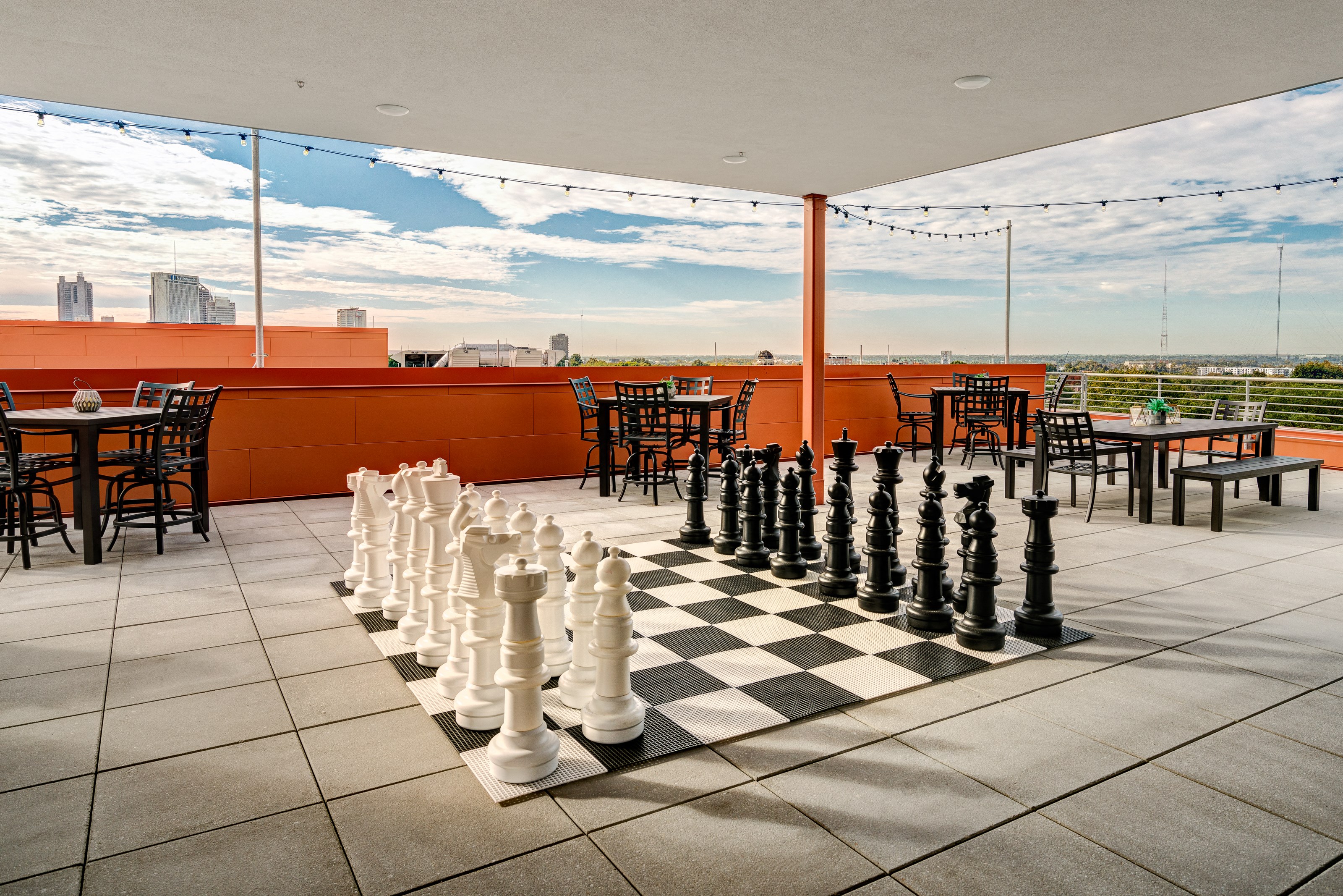 a chess board set up on the rooftop of a restaurant with a view of the