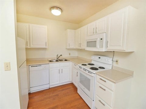 a kitchen with white appliances and white cabinets