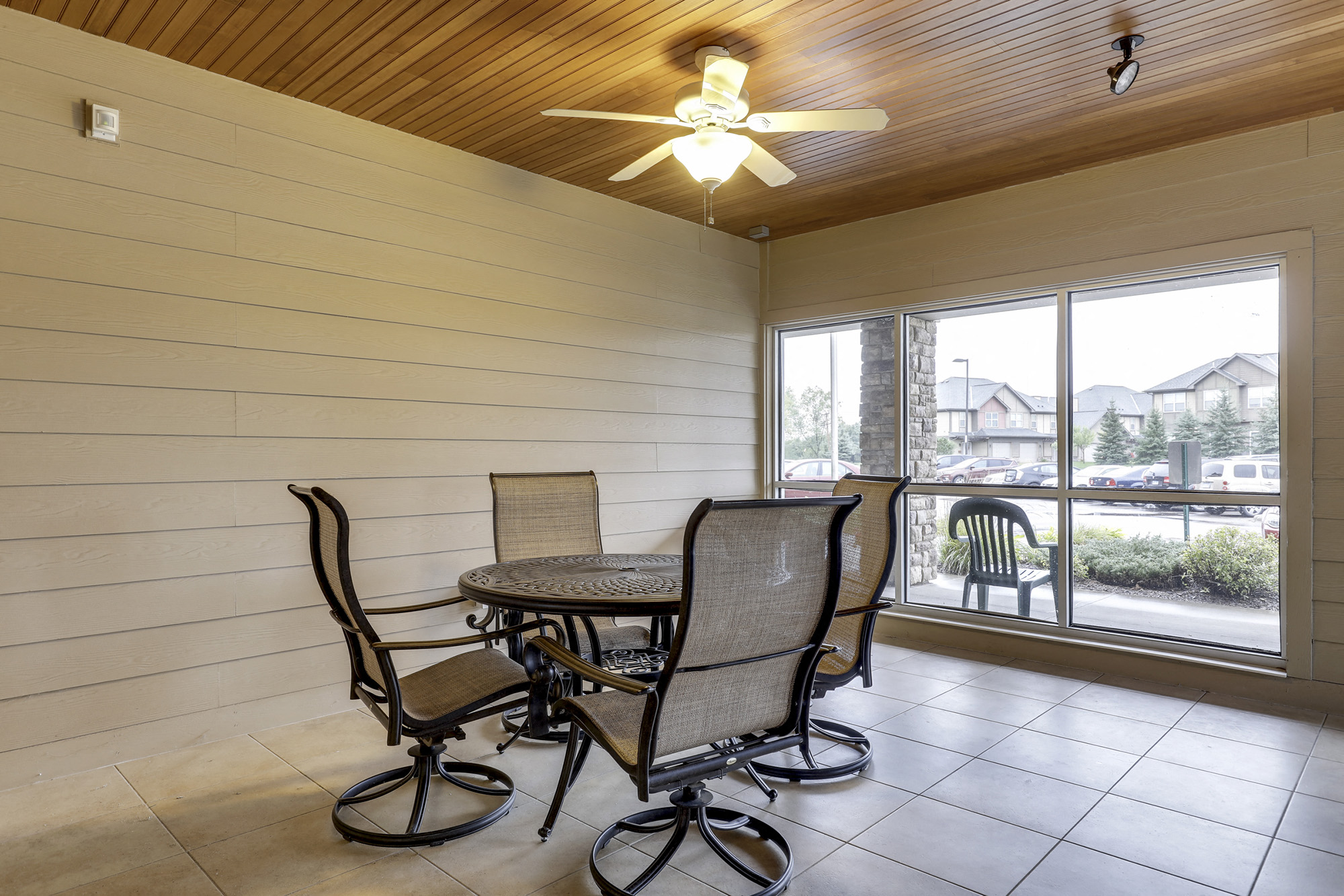 a patio with a table and chairs and a ceiling fan