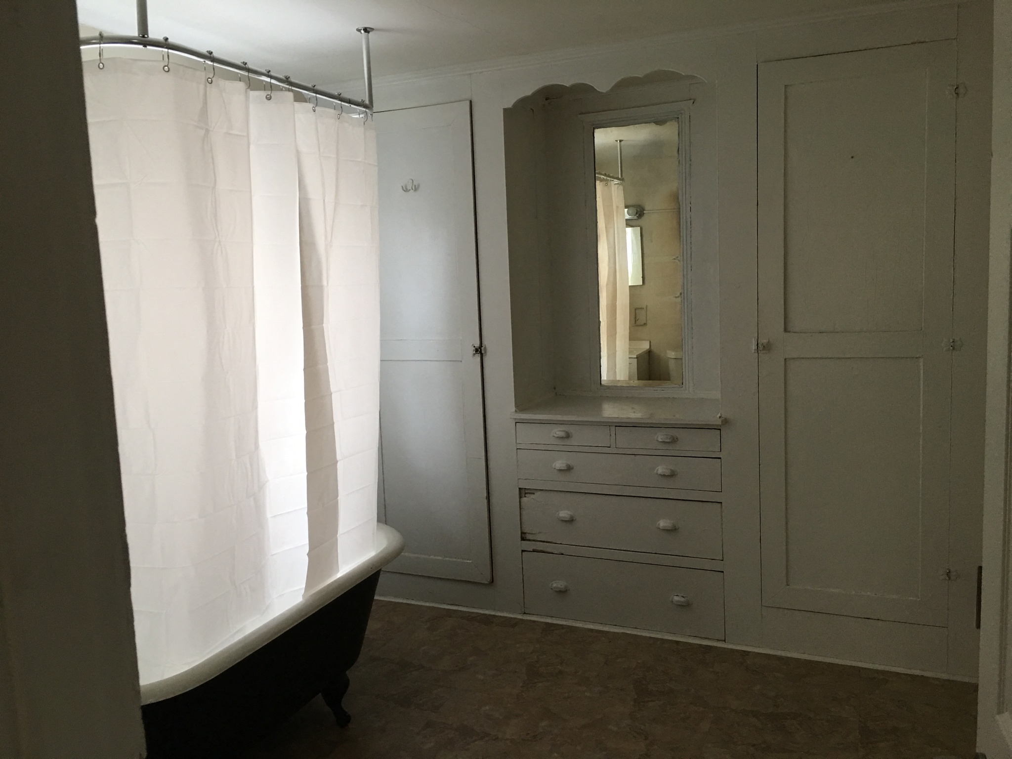 a bathroom with a tub and a dresser and a mirror