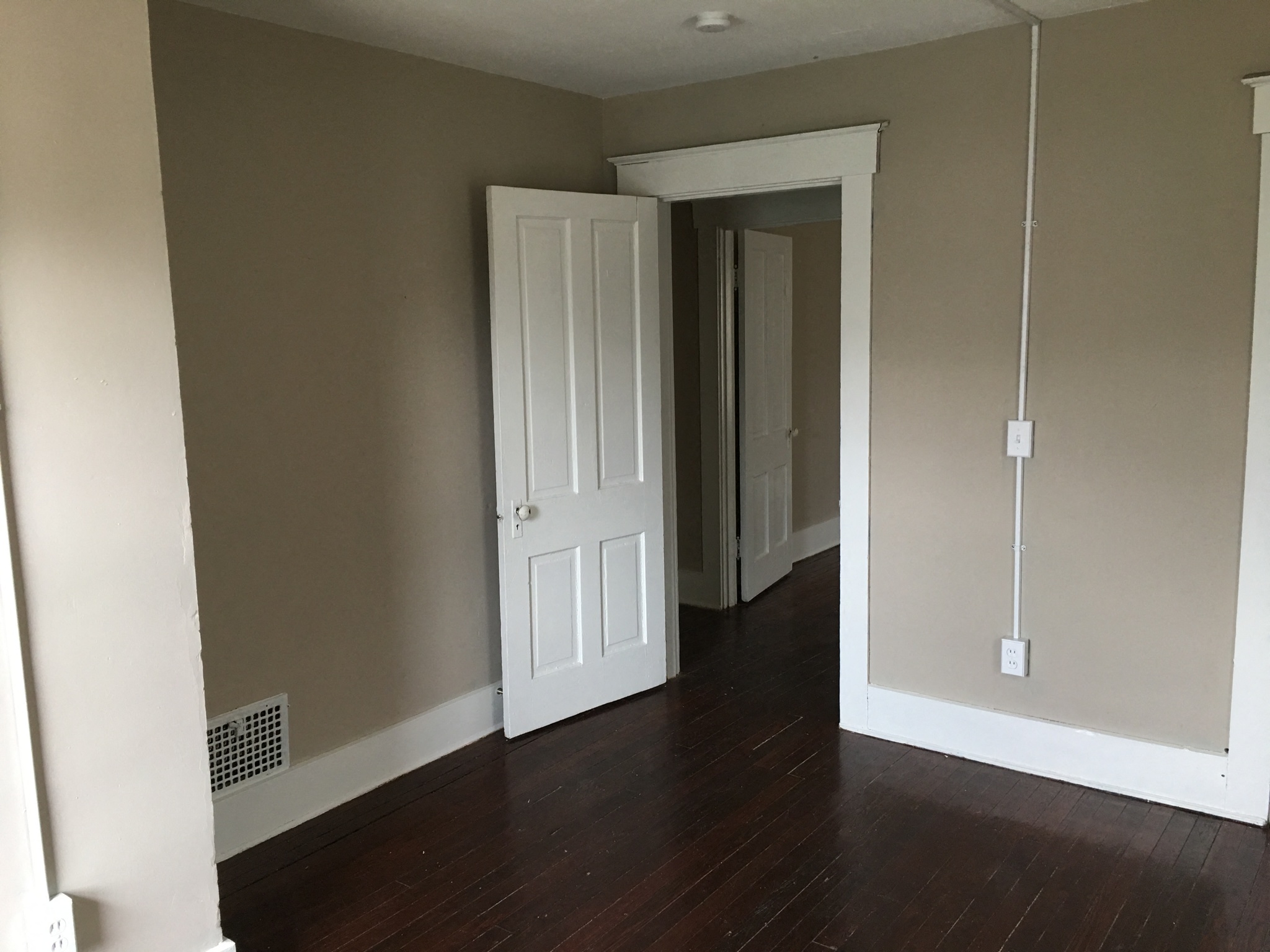 an empty room with wood floors and a white door