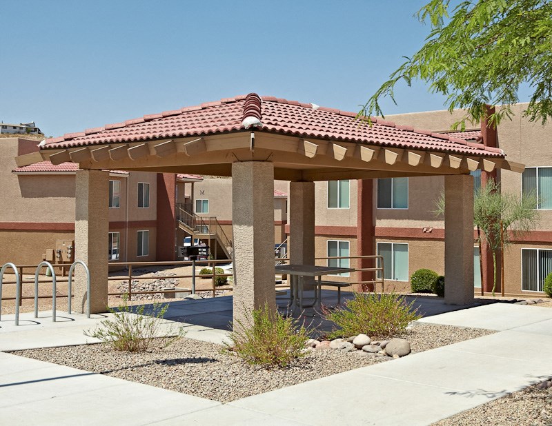 a covered patio with a table in front of a building