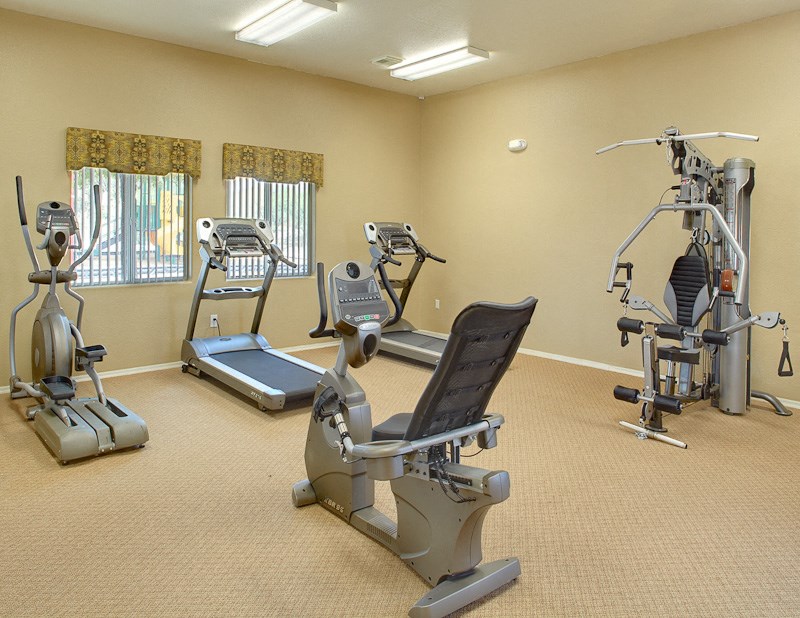 a gym with several machines and weights in a room