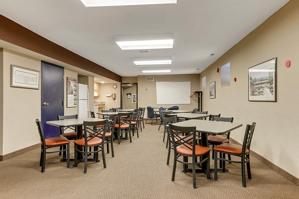 a dining room with tables and chairs and a chalkboard