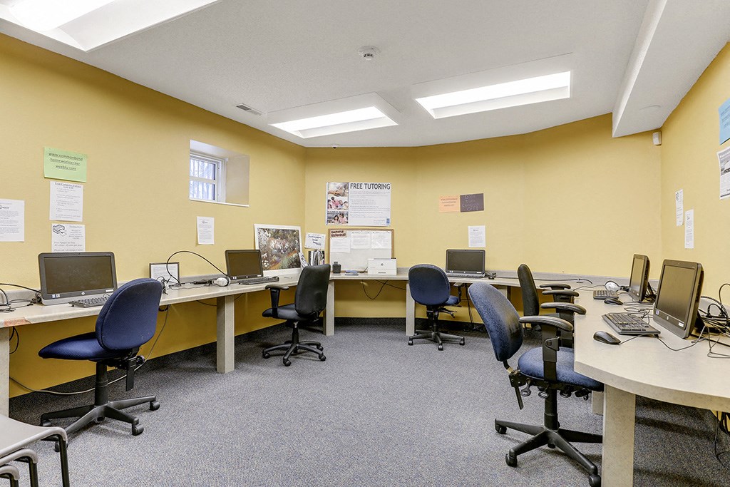 a classroom with desks and chairs and computers in it