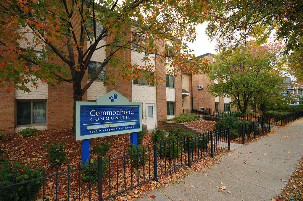 a sign in front of an apartment building