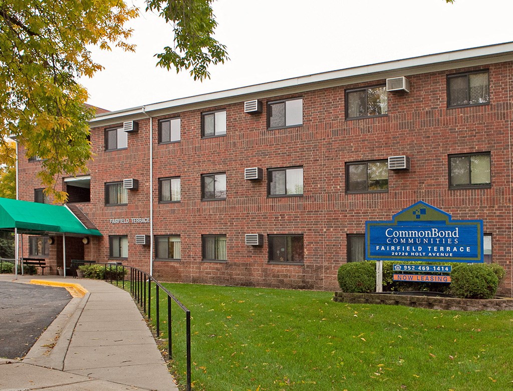 a brick building with a blue sign in front