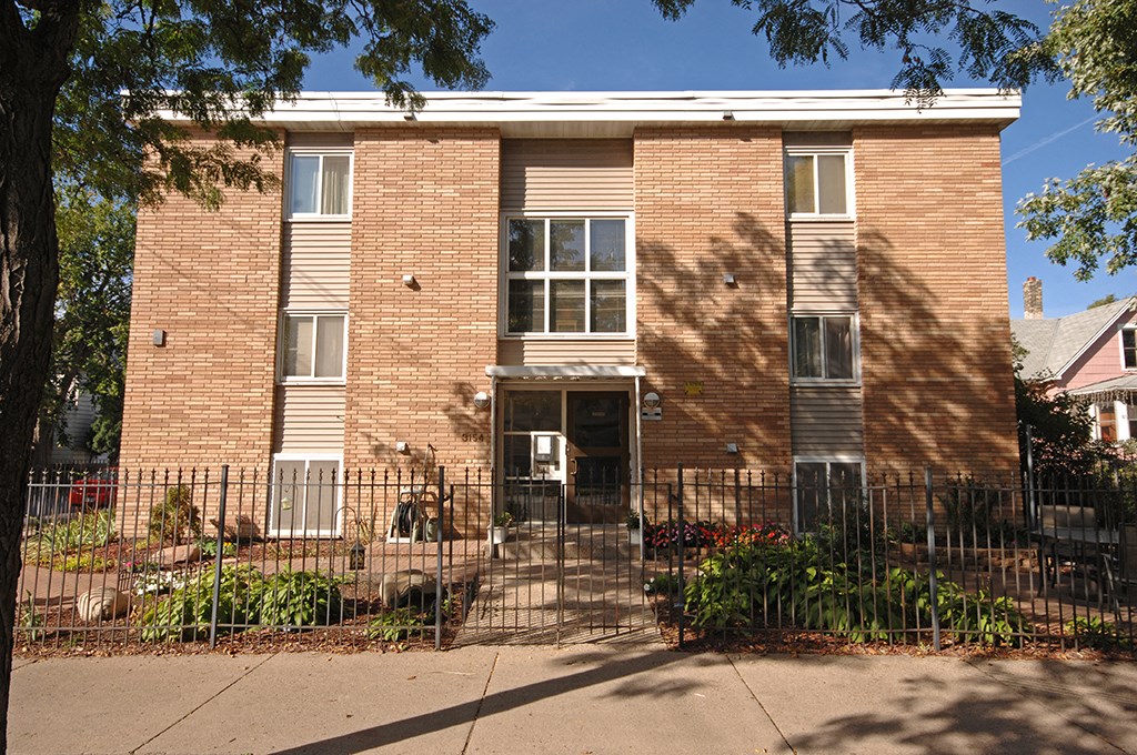 a brick building with a fence in front of it