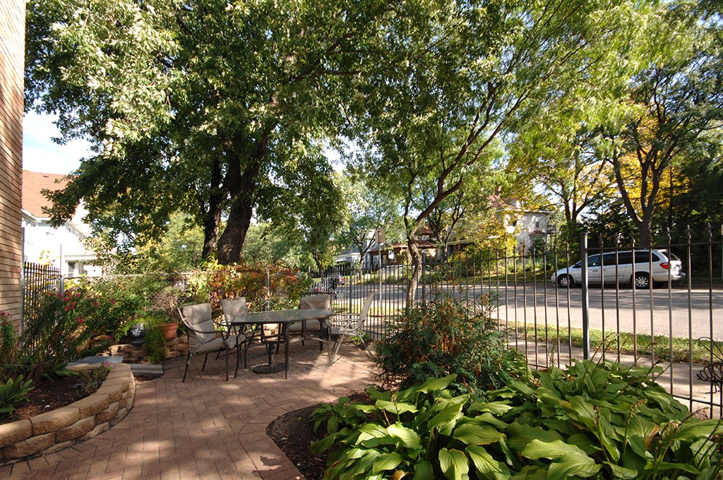 a patio with a table and chairs next to a fence