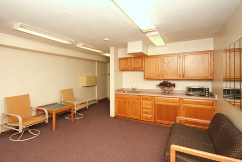 a multipurpose room with a kitchen and chairs and a couch