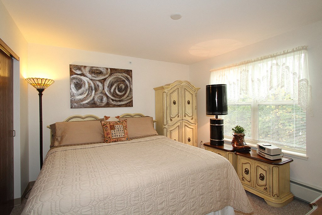 a bedroom with a bed and a painting on the wall