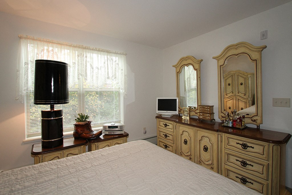 a bedroom with a bed and a dresser and a tv