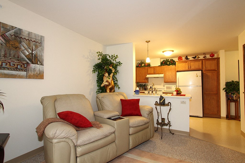 a living room with a couch and a chair and a kitchen