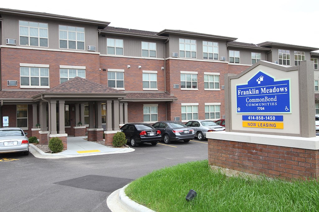 a building with a sign in front of a parking lot
