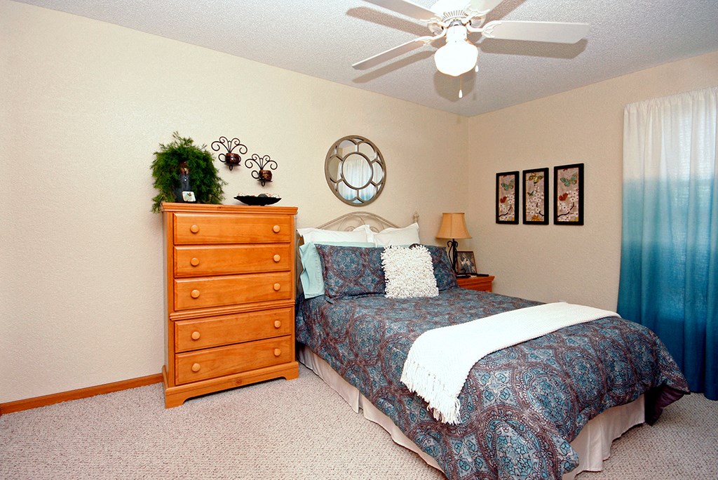 a bedroom with a bed and a ceiling fan