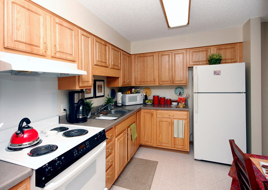 a kitchen with white appliances and wooden cabinets