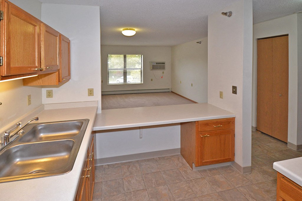 an empty kitchen with a sink and a counter