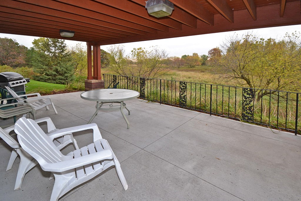 a patio with chairs and a table on a porch