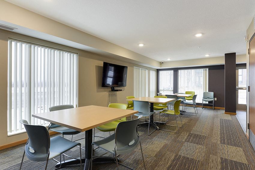 a conference room with tables and chairs and a television