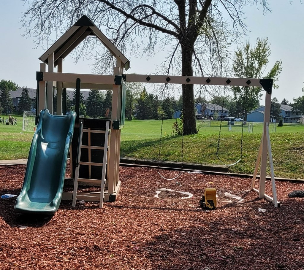 a playground with a swing set and a slide