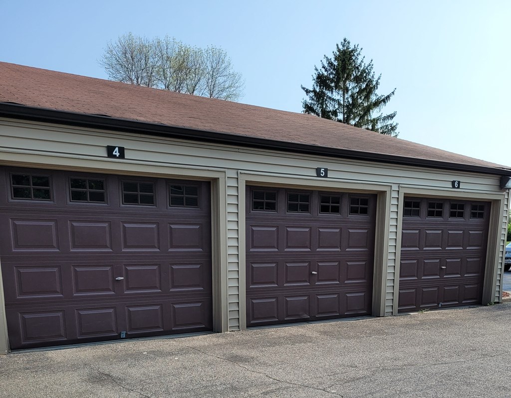 the front of a garage with brown garage doors