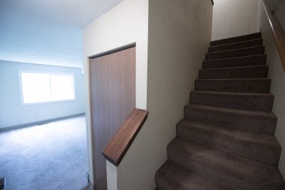 a staircase in a house with a wooden door next to it