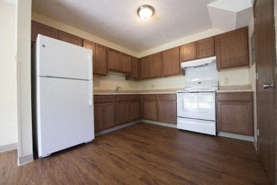 an empty kitchen with a refrigerator and a stove