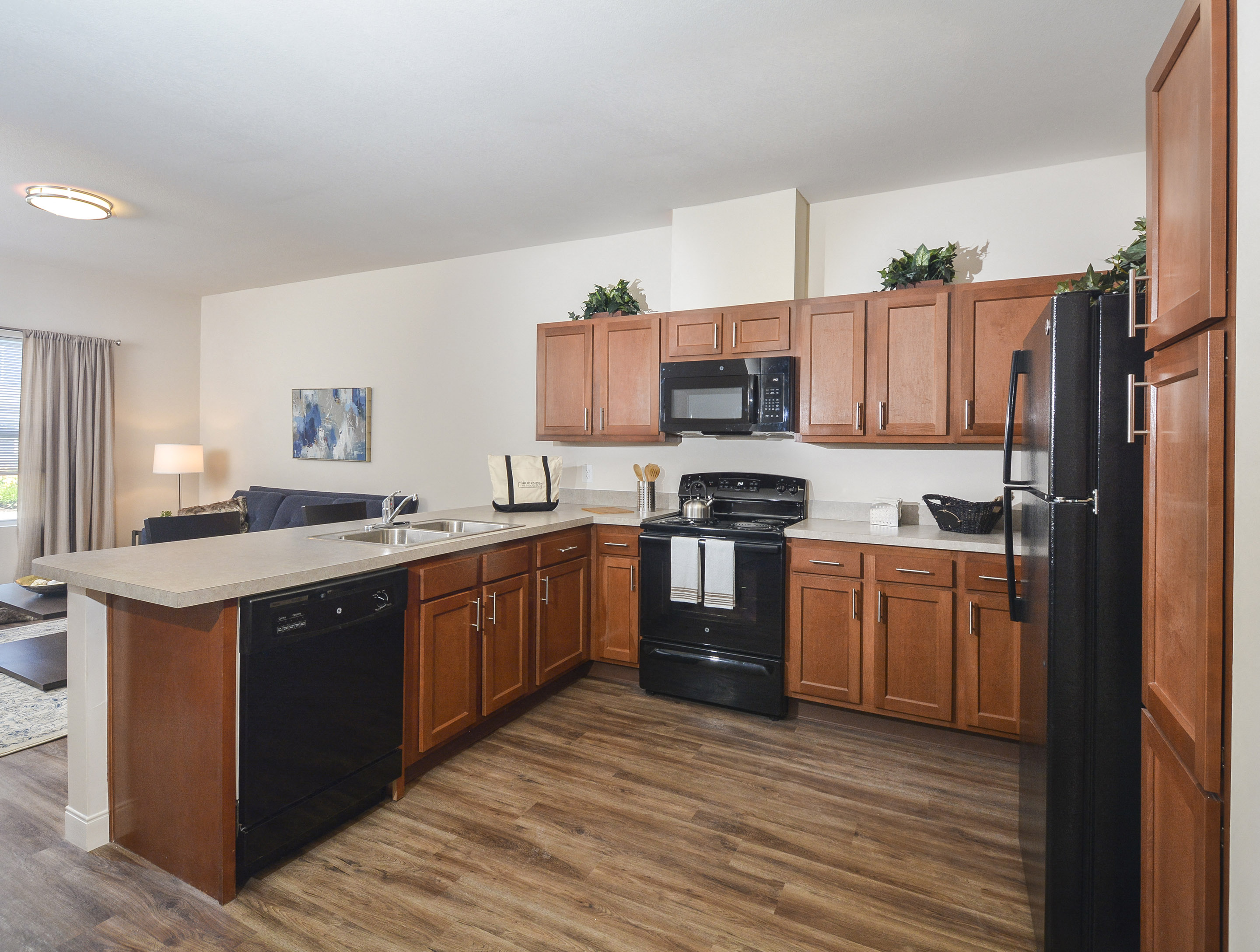 a kitchen with wooden cabinets and a black stove and refrigerator