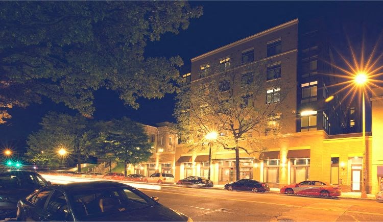 a city street at night with cars parked