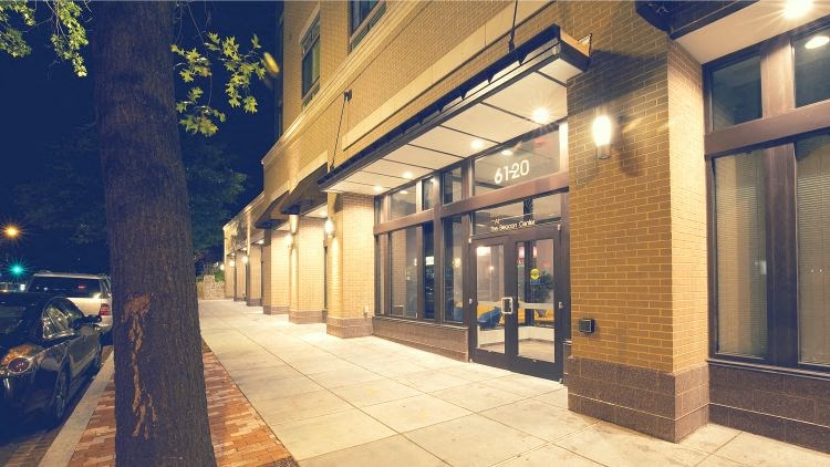 a building with a tree on the sidewalk