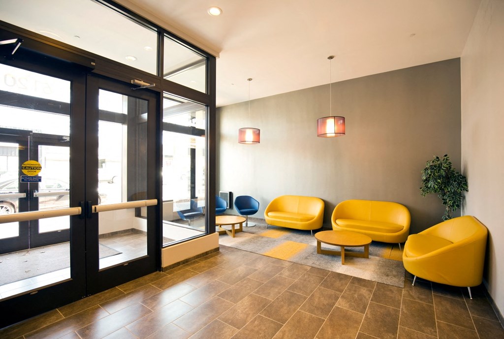 a lobby with yellow chairs and glass doors