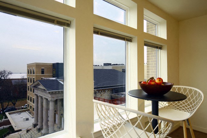 a balcony with a chair and a table with a bowl of fruit