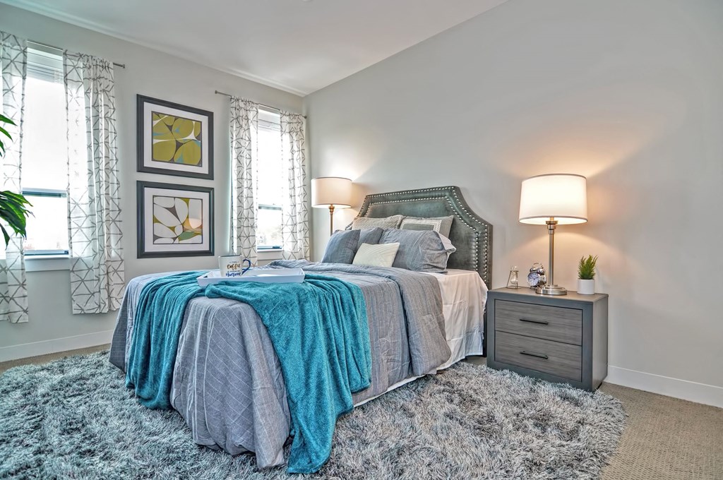 a bedroom with a bed with blue blankets and pillows